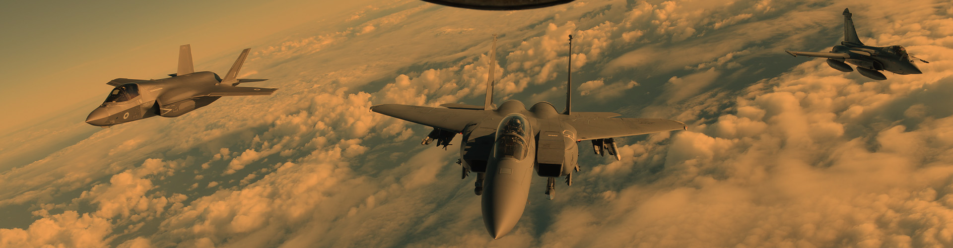 Advanced fighter jets flying in formation above the clouds representing the Global Defense Aerospace Industry and modern military aviation
